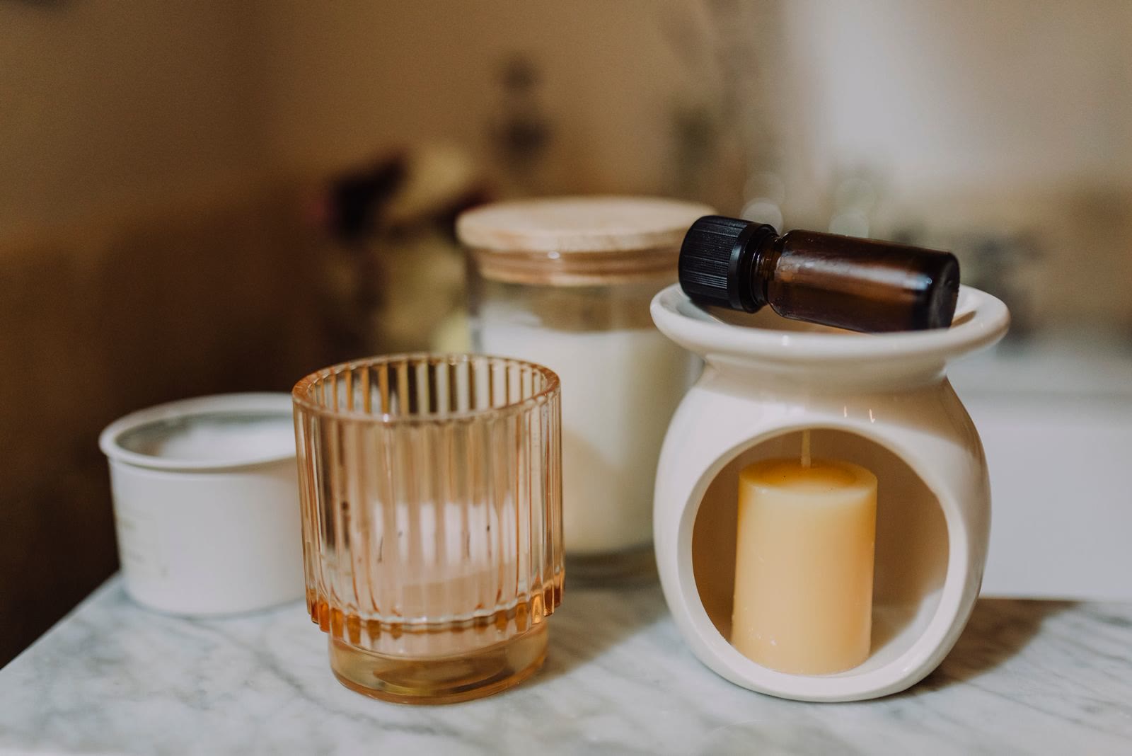 Candele in vasetti di vetro e ceramica su un piano di marmo
