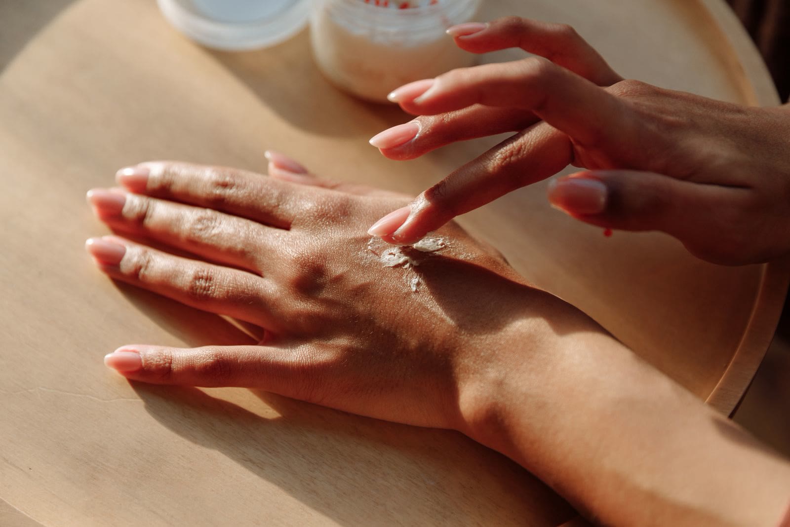 Due mani che stendono una crema